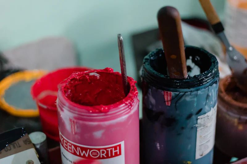 Open jars of pink and green screen printing ink